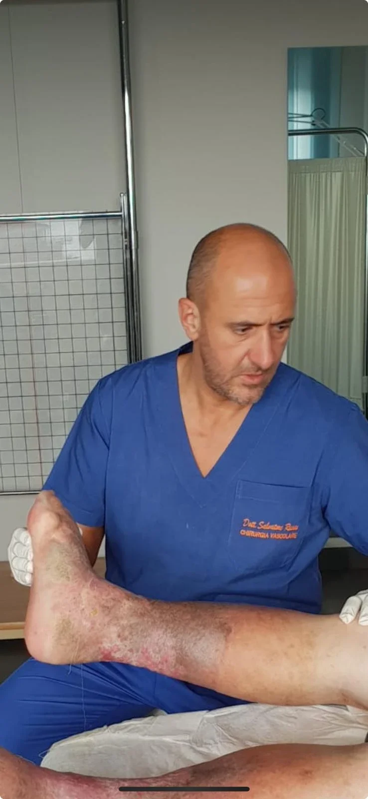 Il Dott. Russo durante la visita di un paziente, con alterazioni della pelle alla gamba e alla caviglia