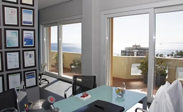 Lo studio con i diplomi alle pareti e le finestre sul mare