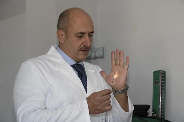 La luce della fibra laser illuminata sul palmo della mano del Dott. Russo