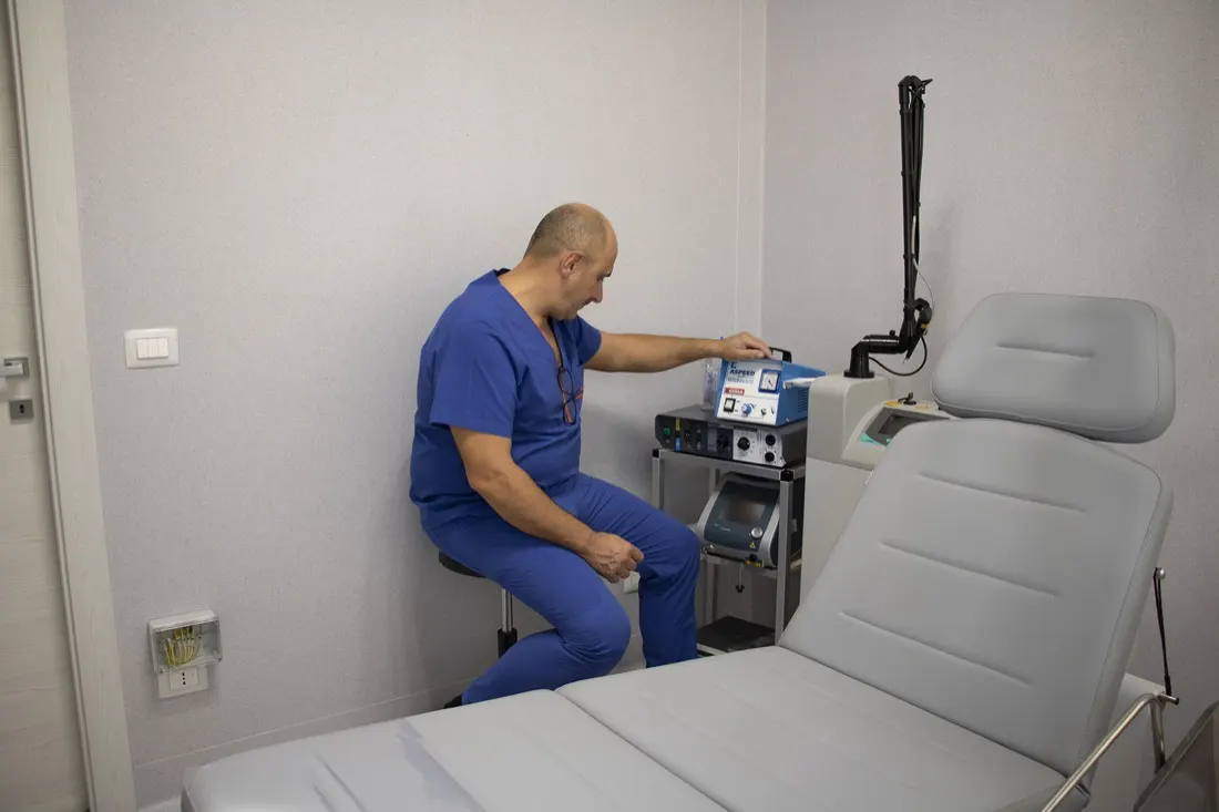 Il Dott. Russo seduto davanti all'apparecchio laser nell'ambulatorio chirurgico